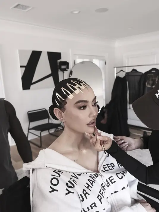 Untuk melengkapi tampilannya, Agnez memakai kacamata hitam berlensa kotak yang memberi sentuhan misterius dan futuristik. Rambutnya ditata sleek ke belakang dengan detail aksesori keemasan di bagian depan yang membuat penampilannya semakin standout. [@agnezmo].