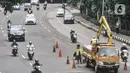Petugas dari Dinas Bina Marga mengerjakan perbaikan jalan berlubang di Jalan DI Panjaitan, Cawang, Jakarta, Senin (25/1/2021). Perbaikan jalan rusak dan berlubang akibat sering tergenang banjir di kawasan tersebut untuk mengantisipasi terjadinya kecelakaan pengendara. (merdeka.com/Iqbal S Nugroho)