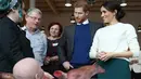 Raut wajah Pangeran Harry dan Meghan Markle saat melihat beberapa anggota tubuh buatan atau prostetik di Catalyst Inc, Belfast, Irlandia Utara, Jumat (23/3). Prostetik tersebut dibuat oleh perusahaan Titanic FX. (Niall Carson/Pool via AP)