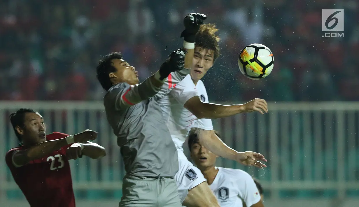 Penjaga gawang Timnas Indonesia U-23. M Ridho (tengah) berebut bola atas dengan pemain Korea Selatan U-23 pada laga persahabatan di Stadion Pakansari, Kab Bogor, Sabtu (23/6). Babak pertama Indonesia U-23 tertinggal 0-1. (Liputan6.com/Helmi Fithriansyah)