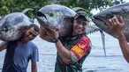 Dengan senyum lebarnya, Aprilio Perkasa Manganang tampil kuat saat membantu nelayan membawa tuna sirip kuning yang berukuran besar. (FOTO: instagram.com/manganang92/)