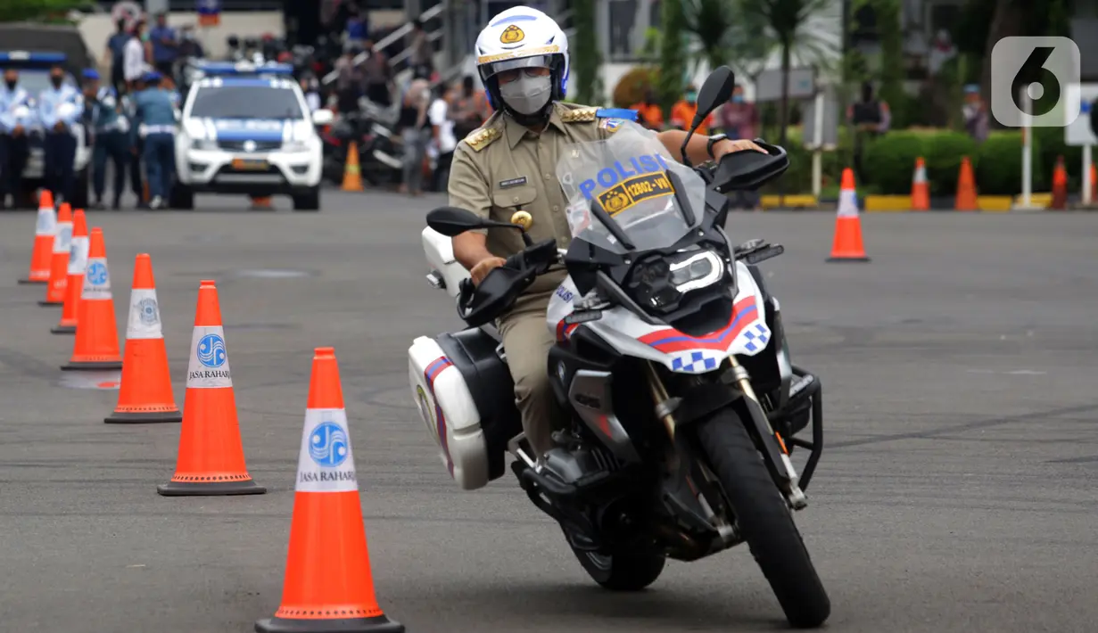 Gubernur DKI Jakarta Anies Baswedan saat menjajal motor usai Apel Gelar Pasukan Operasi Zebra Jaya 2021 di Polda Metro Jaya, Jakarta, Senin (15/11/2021). Operasi Zebra Jaya 2021 digelar karena meningkatnya volume lalu lintas dan kemacetan selama PPKM Level 1. (Liputan6.com/Herman Zakharia)