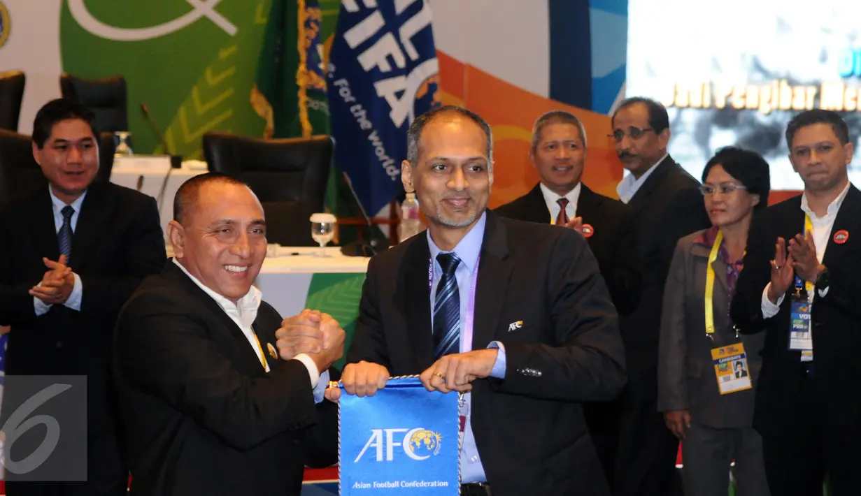 Edy Rahmayadi (kedua kiri) menerima plakat dari perwakilan AFC usai terpilih menjadi Ketua Umum PSSI pada kongres biasa di Jakarta, Kamis (10/11). Edy Rahmayadi meraih suara 76 dari 107 pemilik hak suara. (Liputan6.com/Helmi Fithriansyah)
