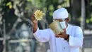 Pemuka Agama Hindu memercikkan air suci saat upacara Melasti menjelang Hari Raya Nyepi Tahun Baru Saka 1943 di Pantai Kuta, Bali (11/3/2021). Ritual Melasti untuk menyucikan alam agar Hari Raya Nyepi dapat berjalan  hening serta damai. (AFP/Sonny Tumbelaka)