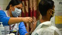 Petugas menyuntikkan vaksin Covid-19 Covaxin kepada seorang pria di sebuah pusat kesehatan di New Delhi, Kamis (21/10/2021). India pada 21 Oktober mencapai 1 miliar dosis vaksin Covid-19, hanya beberapa bulan setelah lonjakan kasus yang membuat sistem kesehatan hampir runtuh. (Prakash SINGH/AFP)