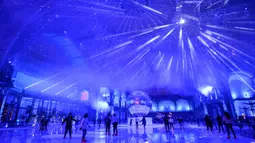 Orang-orang berseluncur di arena ice skating di bawah kubah kaca mewah legendaris, Grand Palais, Paris, Selasa (17/12/2019). Arena ice skating musiman ini menjadi yang terbesar di Prancis, dan satu magnet wisata sepanjang tahun. (Photo by Thomas SAMSON / AFP)