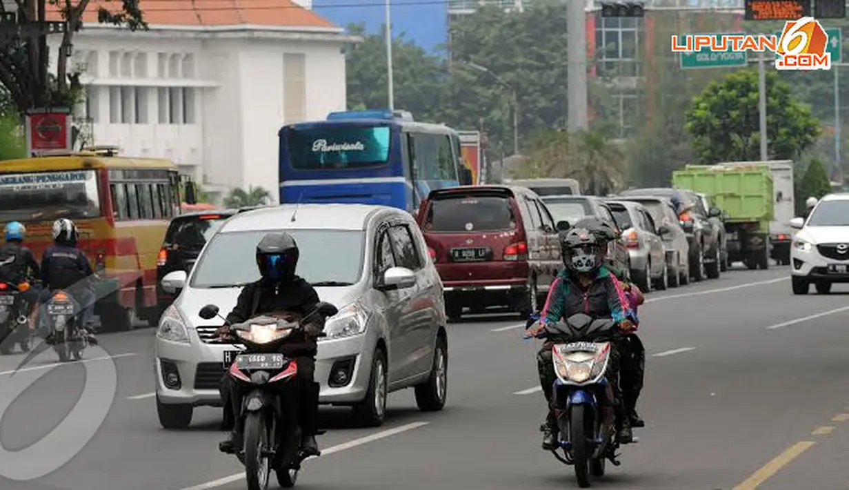 Untuk menghindari abu yang masuk ke pernapasan beberapa pengendara motor yang melintas di Jl Pandanaran terlihat menggunakan masker pelindung (Liputan6.com/Helmi Fithriansyah).