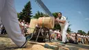 Peserta menggergaji batang pohon dengan "tronza", gergaji tradisional daerah Basque, pada hari ketiga festival San Fermin di Pamplona, Spanyol, Senin (8/7/2019). Festival San Fermin menghadirkan beberapa olahraga pedesaan Basque seperti menggergaji dan memotong pohon dengan kapak. (JAIME REINA/AFP)