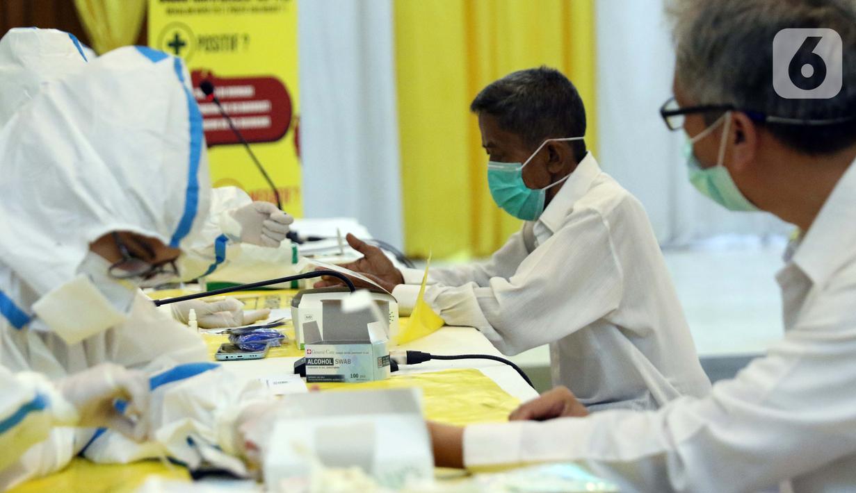 Petugas medis melakukan Rapid Test COVID-19 di DPP Partai Golkar, Jakarta, Rabu (8/4/2020). Rapid test dilakukan untuk memeriksa virus menggunakan antibodi IgG dan IgM yang ada di dalam darah, antibodi akan terbentuk di tubuh saat mengalami infeksi virus. (Liputan6.com/Helmi Fithriansyah)