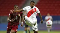 Bek timnas Peru, Miguel Araujo mengontrol bola dibayangi penyerang Venezuela, Sergio Cordova pada laga terakhir penyisihan Grup B  Copa America 2021 di Estadio Nacional Mane Garrincha, Minggu (27/6/2021). Menghadapi Venezuela, Peru menang tipis dengan skor 1-0. (SILVIO AVILA / AFP)