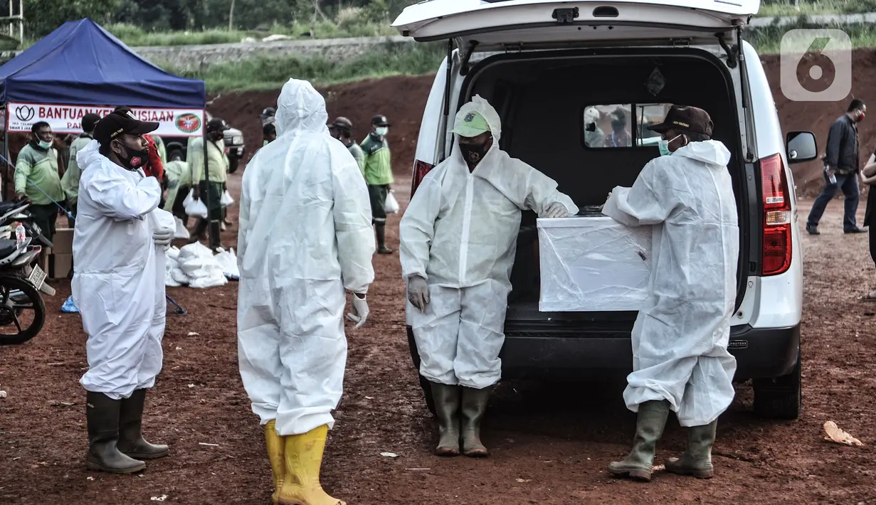 Petugas mengenakan alat pelindung diri dan baju hazmat saat proses pemakaman protap Covid-19 di TPU Pondok Ranggon, Jakarta, Senin (28/9/2020). Diketahui pemakaman protap Covid-19 di Ibu Kota hingga saat ini mencapai 6.248 orang. (merdeka.com/Iqbal S. Nugroho)