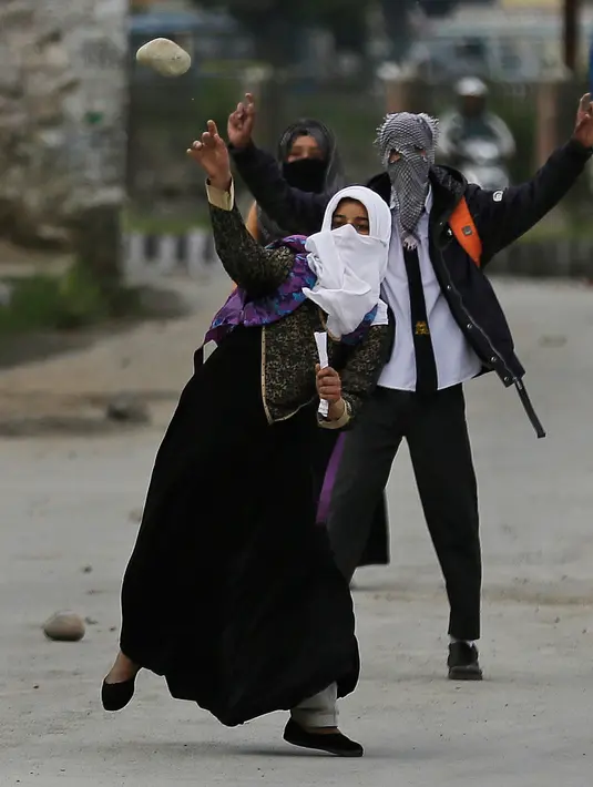 Pelajar Kashmir melempari seorang polisi India saat bentrok di Srinagar, Kashmir, Rabu (17/5). Beberapa bulan belakangan ini keadaan di Kashmir terus diwarnai oleh bentrok antara pelajar dengan polisi. (AP Photo / Mukhtar Khan)