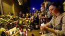 Seorang wanita menyalakan lilin di depan Kedutaan Besar Belanda di Kiev, Ukraina, Jumat (17/7/14). (AFP PHOTO/Sergei Supinsky)