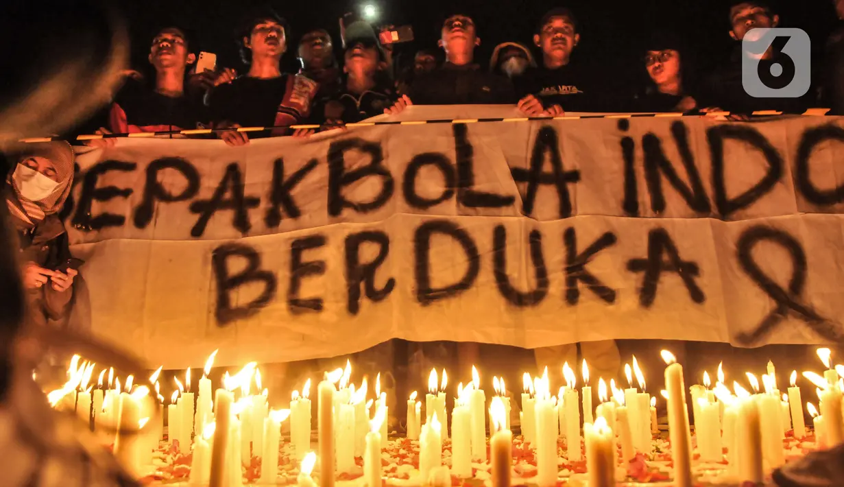 Massa yang tergabung dalam Ultras Garuda Jakarta menggelar aksi seribu lilin dan tabur bunga untuk korban kerusuhan Stadion Kanjuruhan Malang di depan Stadion Gelora Bung Karno (GBK), Jakarta, Minggu (2/10/2022). Aksi yang diikuti ratusan pecinta sepakbola di Jakarta tersebut sebagai bentuk belasungkawa terhadap ratusan korban yang tewas dalam kerusuhan di Stadion Kanjuruhan Malang kemarin. (merdeka.com/Iqbal S Nugroho)