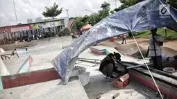 Pekerja memperbaiki arena skateboard yang rusak di RPTRA Kalijodo, Jakarta, Kamis (24/1). Perbaikan dilakukan untuk membuat rasa aman dan nyaman pengunjung yang menggunakan arena tersebut. (Liputan6.com/Faizal Fanani)