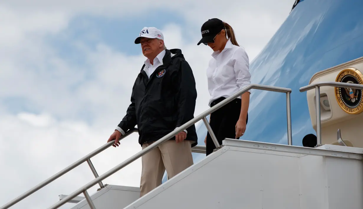 Presiden AS, Donald Trump dan Ibu Negara Melania Trump turun dari pesawat kepresidenan di Bandara Internasional Austin, Texas, Selasa (29/8). Trump mencoba menyemangati warganya lewat kunjungan ke Texas yang dihantam badai Harvey. (AP Photo/Evan Vucci)