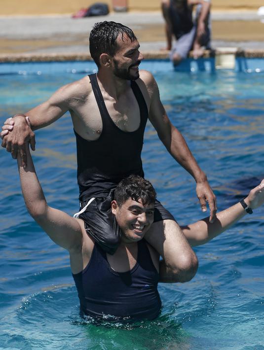 Pemuda Palestina yang diamputasi saat mengikuti renang di bawah instruksi Majdi al-Tatar di Kota Gaza (30/7/2019). Tatar melatih warga Palestina yang diamputasi untuk membantu mereka mempertahankan aktivitas fisik. (AFP Photo/Mahmud Hams)