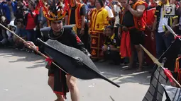 Pemuda peduli Nias melakukan atraksi perang kampung di kawasan Jalan Jenderal Sudirman, Jakarta, Minggu (4/3). Pemuda Peduli Nias melakukan beragam atraksi budaya untuk mempromosikan pariwisata di pulau tersebut. (Liputan6.com/Helmi Fithriansyah)