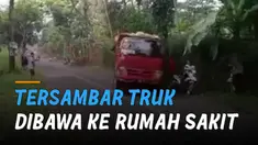 Ketika truk berwarna merah melintas, bokong truk itu mengenai salah satu perekam video.