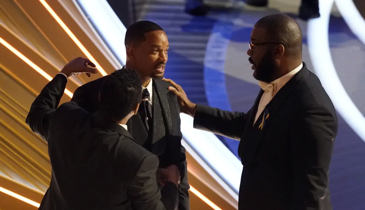 Will Smith tampak ditenangkan oleh Sean Combs dan Tyler Perry saat perhelatan Piala Oscar 2022 di Dolby Theatre, Minggu (27/3/2022). Will Smith memukul Chris Rock lantaran merasa lawakan sang komedian terkait istrinya, Jada Pinkett Smith keterlaluan. (AP Photo/Chris Pizzello)
