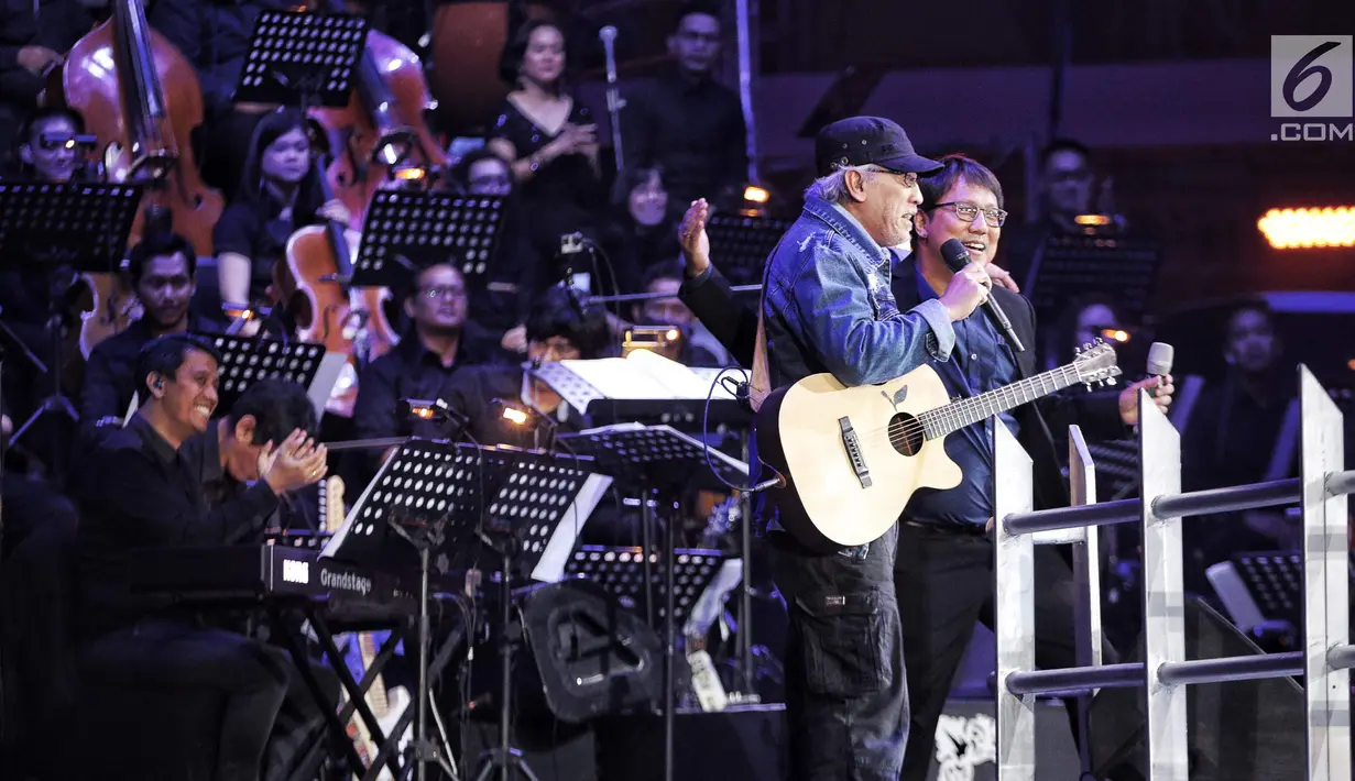 Iwan Fals bersama Erwin Gutawan saat tampil dalam malam puncak Hut SCTV ke-28 di ICE BSD, Tangerang, Jumat (24/8). Dalam penampilannya Iwan Fals membawakan lagu berjudul "Buku ini aku pinjam" dan "Mata Indah Bola Pimpong". (Liputan6.com/Faizal Fanani)
