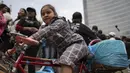 Seorang gadis duduk di atas sepeda penjual taco saat acara pemecahan rekor taco terbanyak yang disajikan dalam satu jam — 30.000 — di monumen Angel of Independence di Mexico City, Minggu, 11 Agustus 2024. (AP Photo/Aurea del Rosario)