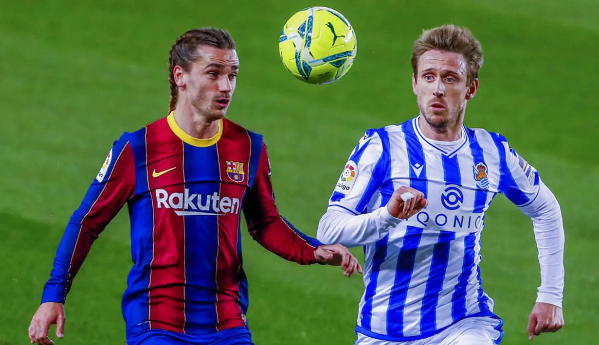 Penyerang Barcelona, Antoine Griezmann, berebut bola dengan pemain Real Sociedad, Nacho Monreal, pada laga Liga Spanyol di Stadion Camp Nou, Kamis (17/12/2020). Barcelona menang dengan skor 2-1. (AP/Joan Monfort)