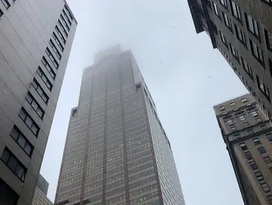 Asap mengepul saat sebuah helikopter menabrak gedung pencakar langit di pusat Manhattan, New York, Amerika Serikat, Senin (10/6/2019). Seorang pilot dilaporkan tewas dalam insiden tersebut. (AP Photo/Mark Lennihan)
