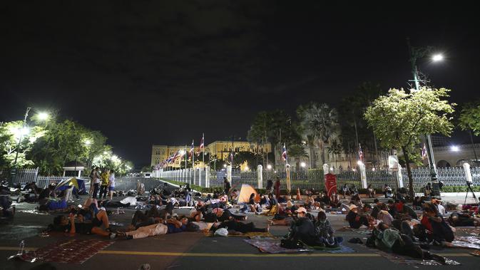 Demonstran pro-demokrasi tidur di depan Gedung Pemerintah selama demonstrasi di Bangkok, Thailand, Kamis (15/10/2020). Polisi Thailand membubarkan demonstran yang berunjuk rasa di luar kantor perdana menteri. (AP Photo/Rapeephat Sitichailapa)