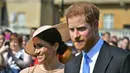 Pangeran Harry dan Meghan Markle menghadiri pesta kebun Istana Buckingham di London, Selasa (22/5). Meghan Markle meninggalkan tampilan rambut messy bun andalannya, untuk beralih gaya rambut sleek dengan bun di samping. (Dominic Lipinski/Pool via AP)