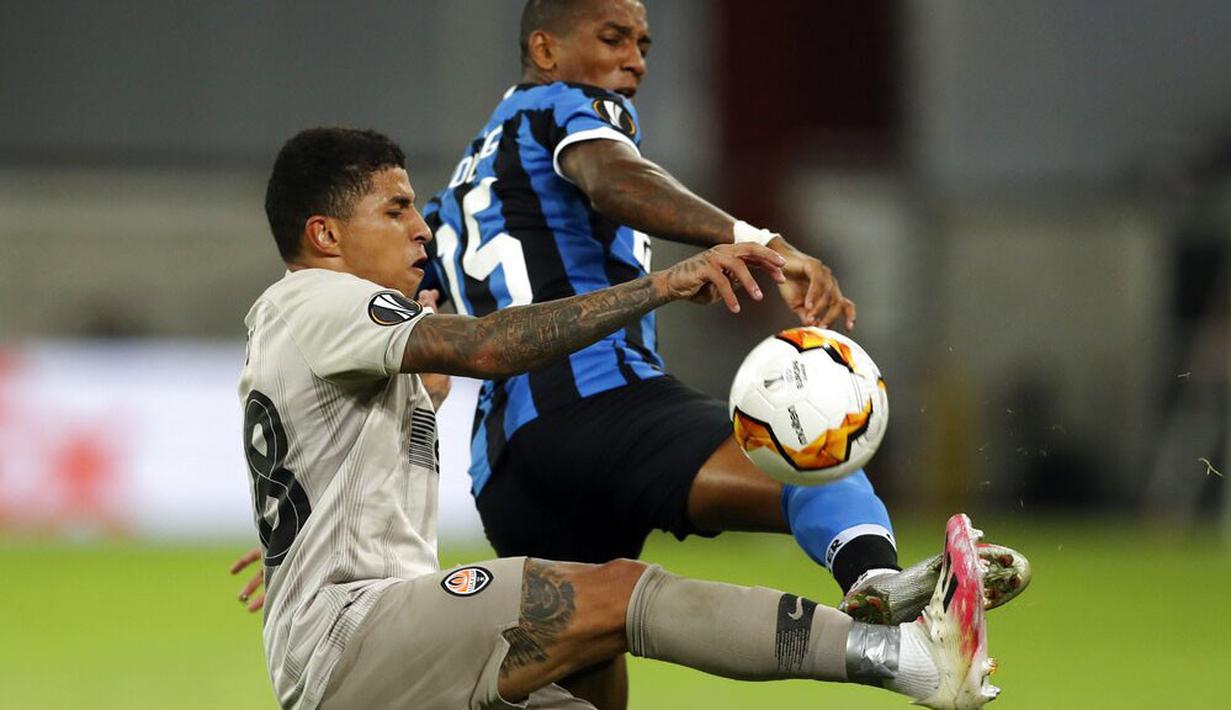 Bek Inter Milan, Ashley Young, berebut bola dengan pemain Shakhtar Donetsk, Dodo, pada laga semifinal Liga Europa di Merkur Spiel-Arena, Selasa (18/8/2020). Inter Milan menang dengan skor 5-0. (Lars Baron/Pool via AP)