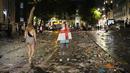 Dua fans Timnas Inggris berjalan diantara sampah yang berserakan di Kota London paska final Euro 2020 antara Timnas Inggris melawan Italia. (Foto:AP/Matt Dunham)