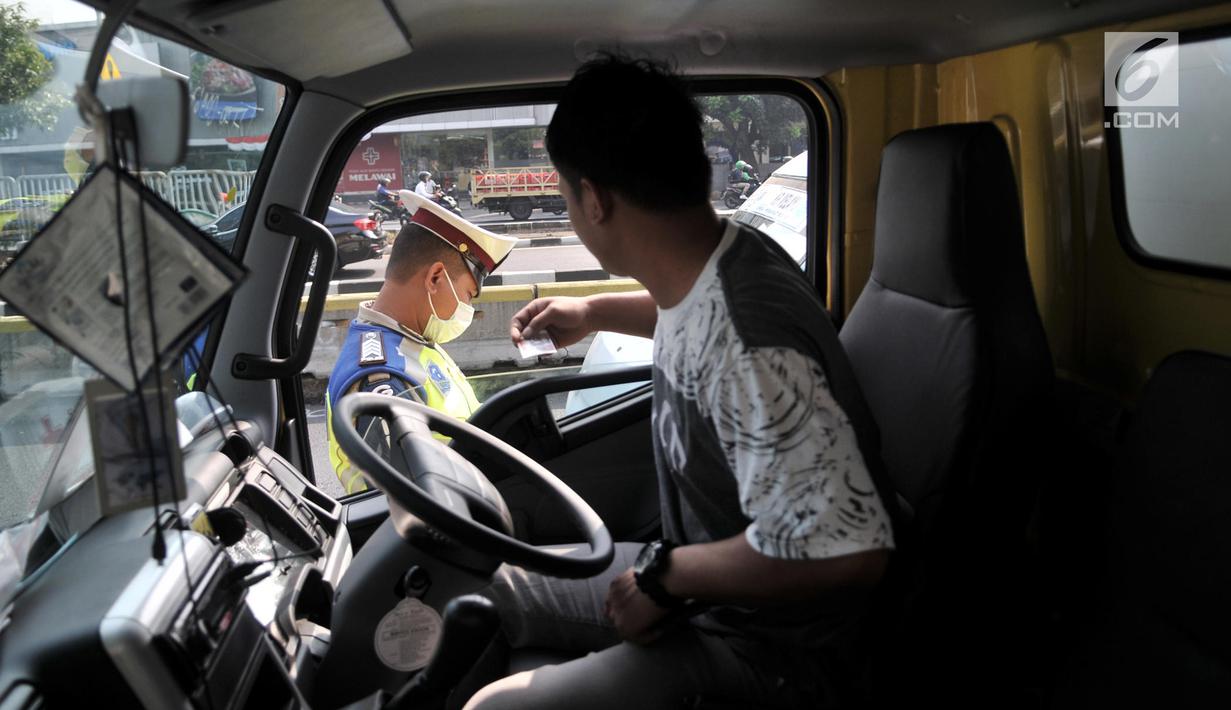 Polisi menilang pengendara yang melanggar pemberlakuan perluasan sistem ganjil genap di Jalan Salemba Raya, Jakarta, Senin (9/9/2019). Terdapat 25 ruas jalan di DKI Jakarta yang diterapkan kebijakan pembatasan kendaraan bermotor ini. (merdeka.com/Iqbal Nugroho)