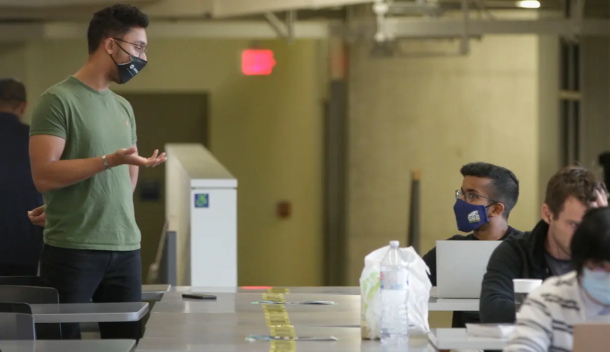 Mahasiswa yang mengenakan masker bercakap-cakap di Universitas British Columbia (UBC) di Vancouver, Kanada, 16 September 2020. Mahasiswa, pengajar, staf dan pengunjung UBC diwajibkan memakai masker saat berada di dalam ruangan di kampus guna meredam penyebaran COVID-19. (Xinhua/Liang Sen)