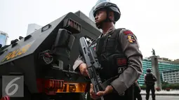 Anggota Brimob dengan senjata lengkap berjaga di sekitar Bundaran HI, Jakarta, Kamis (24/12). Polda Metro Jaya mengerahkan 8.978 personel untuk operasi lilin jaya 2015 dalam rangka pengamanan Natal 2015 dan tahun baru 2016. (Liputan6.com/Faizal Fanani)