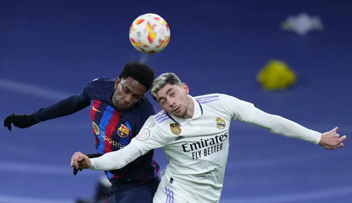 Pemain Barcelona, Alejandro Balde (kiri) berduel udara dengan pemain Real Madrid, Federico Valverde pada laga leg pertama semifinal Copa Del Rey 2022/2023 di Santiago Bernabeu, Madrid, Jumat (03/03/2023) WIB. Laga berakhir dengan skor 1-0 untuk kemenangan Barcelona. (AP Photo/Manu Fernandez)