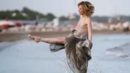 Sonia Bergamasco menggunakan kakinya saat bermain air di pantai sebelum Festival film Venice ke-73 di Venice, Italia (30/8). Festival film Venice tersebut digelar hingga 10 September. (REUTERS/Alessandro Bianchi)