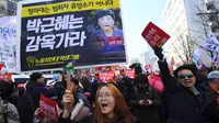 Aktivis anti-pemerintah membawa spanduk sambil merayakan pemakzulan Presiden Korea Selatan Park Geun-hye oleh Mahkamah Konstitusi di Seoul, Jumat (10/3). MK Korsel menyatakan Presiden Park Geun-Hye telah melanggar Konstitusi dan hukum. (JUNG Yeon-Je/AFP)