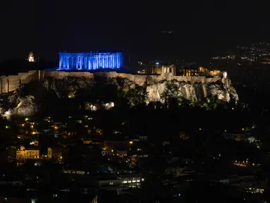 Situs warisan dunia Kuil Parthenon berwarna biru saat Hari Anak Sedunia, Athena, Yunani, Rabu (20/11/2019). Nuansa biru pada kuil yang berada di puncak bukit Acropolis tersebut untuk memperingati Hari Anak Sedunia yang jatuh setiap tanggal 20 November. (AP Photo/Petros Giannakouris)