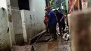 Petugas Damkar PB membersihkan lumpur sisa banjir di salah satu gang di kawasan Rawajati, Jakarta, Sabtu (27/4). Banjir akibat luapan air sungai Ciliwung sempat melanda kawasan ini pada Jumat (26/4). (Liputan6.com/Helmi Fithriansyah)