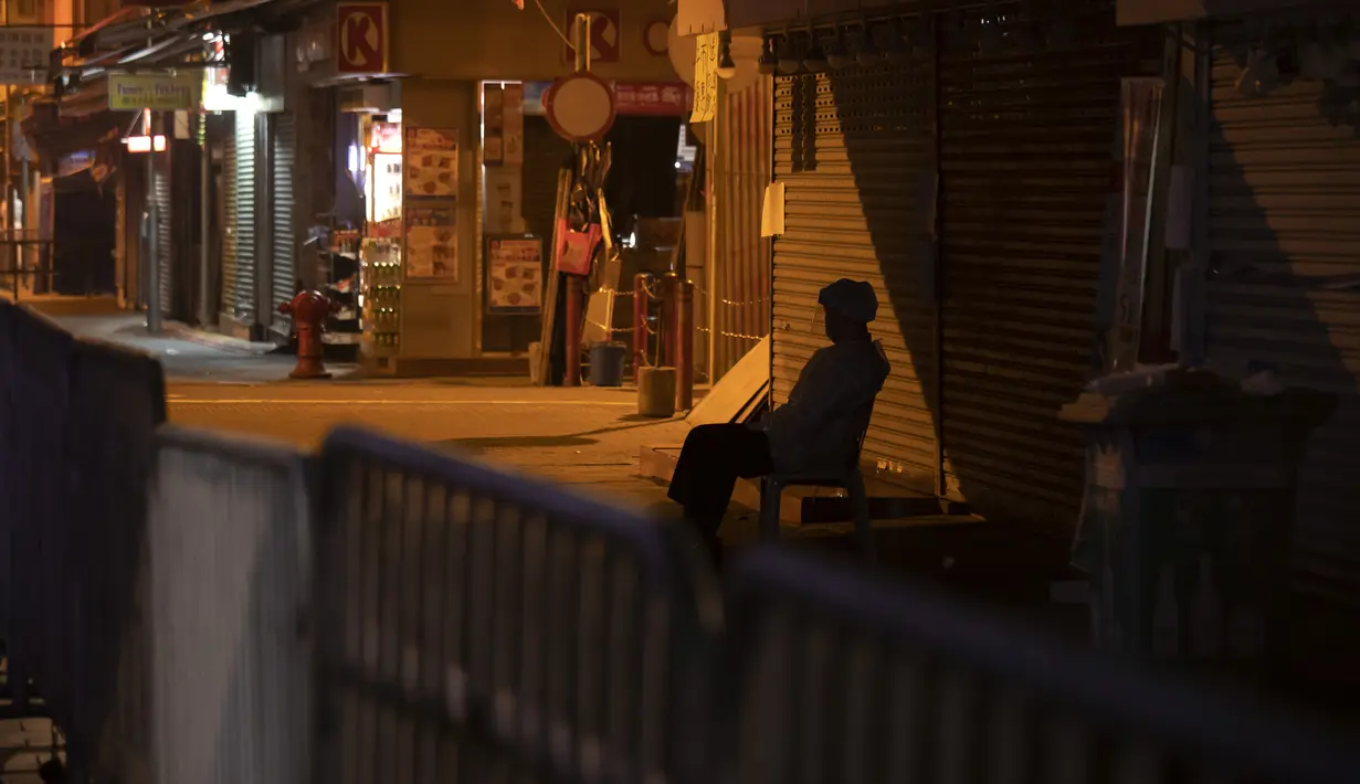 Seorang petugas kesehatan mengenakan APD berjaga di area tertutup di distrik Jordan, di Hong Kong, Minggu (24/1/2021). Penutupan wilayah itu dilakukan sementara Hong Kong menghadapi gelombang infeksi Covid-19 keempat dalam dua bulan.a(AP Photo/ Kin Cheung)