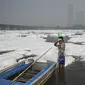 Seorang pria mandi di sungai Yamuna yang tertutup busa limbah di New Delhi, Senin (8/11/2021). Sungai yang sangat dianggap suci oleh umat Hindu India ini dipenuhi lapisan busa karena limbah beracun. (Sajjad HUSSAIN / AFP)