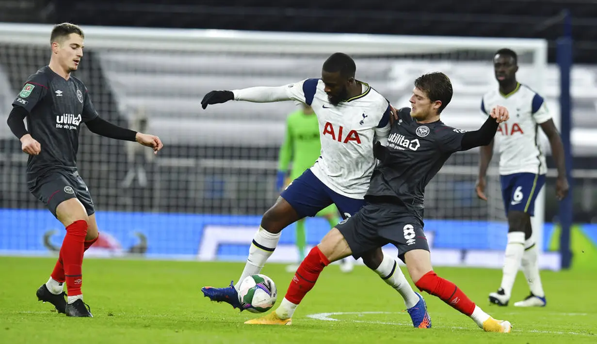 Pemain Tottenham Hotspur Tanguy Ndombele (tengah)  berebut bola dengan pemain Brentford Mathias Jensen (tengah kanan) pada pertandingan semifinal Piala Liga Inggris di Tottenham Hotspur Stadium, London, Inggris, Selasa (5/1/2021). Tottenham Hotspur menang 2-0. (Glyn Kirk/Pool via AP)