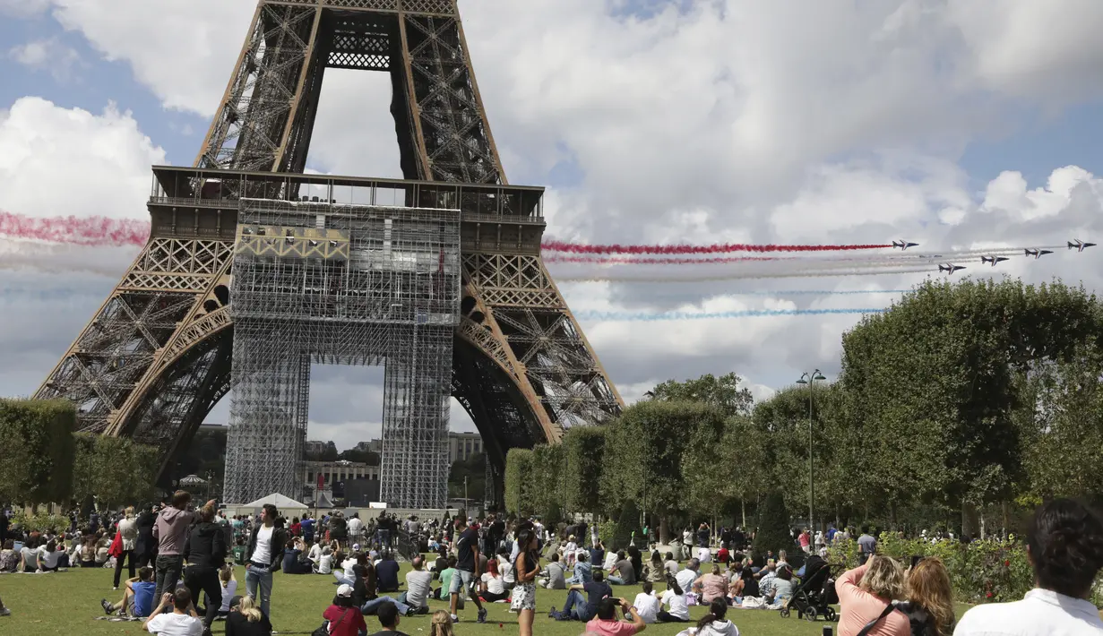 Jet dari angkatan udara Prancis Patrouille de France terbang di atas Menara Eiffel dan melewati zona penggemar Olimpiade di Paris, Minggu (8/8/2021). Pesta olahraga terbesar dunia itu pun akan kembali digelar pada 2024 mendatang di Paris, Prancis. (AP Photo/Adrienne Surprenant)