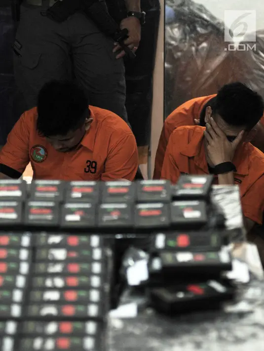 Tersangka tertunduk saat rilis pengembangan kasus pembuatan liquid vape narkoba di Kelapa Gading, Jakarta, Kamis (8/11). Hingga saat ini polisi telah meringkus 18 tersangka kasus pembuatan liquid vape narkoba. (Merdeka.com/Iqbal Nugroho)