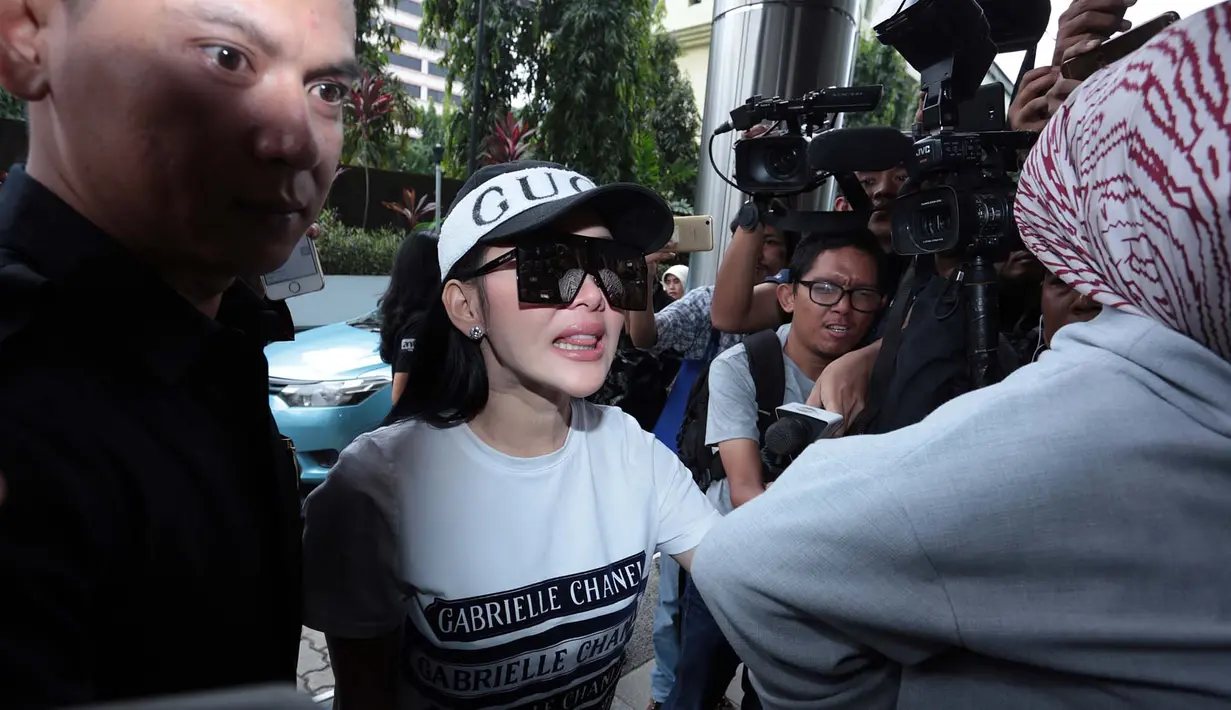 Turun dari mobil yang ditumpangi, Toyota Alphard Syahriini tampil dengan mengenakan topi Gucci dan berkaca mata hitam berbentuk kotak. Ia tampil santai dengan kaos warna putih, dan celana warna hitam. Usai pemeriksaan Syahrini santai. (Deki Prayoga/Bintan