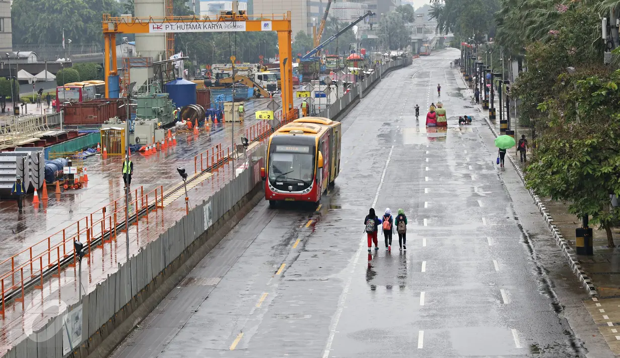 Hujan yang mengguyur Ibukota sejak semalam hingga pagi membuat kawasan CFD sepi pengunjung, Jakarta, Minggu (28/2/2016). Tampak sejumlah warga tetap berktivitas di kawasan CFD. (Liputan6.com/Immanuel Antonius)