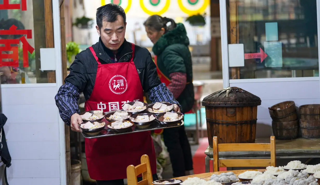 Warga lokal Kota Kuno Zhongshan membuat makanan tradisional untuk merayakan Tahun Baru Imlek di Distrik Jiangjin, Chongqing, China, Jumat (17/1/2020).  (Xinhua/Liu Chan)