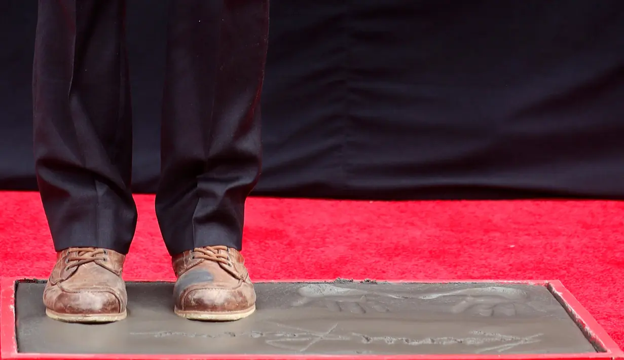 Aktor Keanu Reeves mengabadikan cetak kakinya di atas semen di halaman depan TCL Chinese Theatre, Los Angeles, Selasa (14/5/2019). Aktor 54 tahun itu mendapat penghargaan membuat cetakan tangan dan kaki untuk merayakan keberhasilan karirnya dalam film. (REUTERS/Mario Anzuoni)