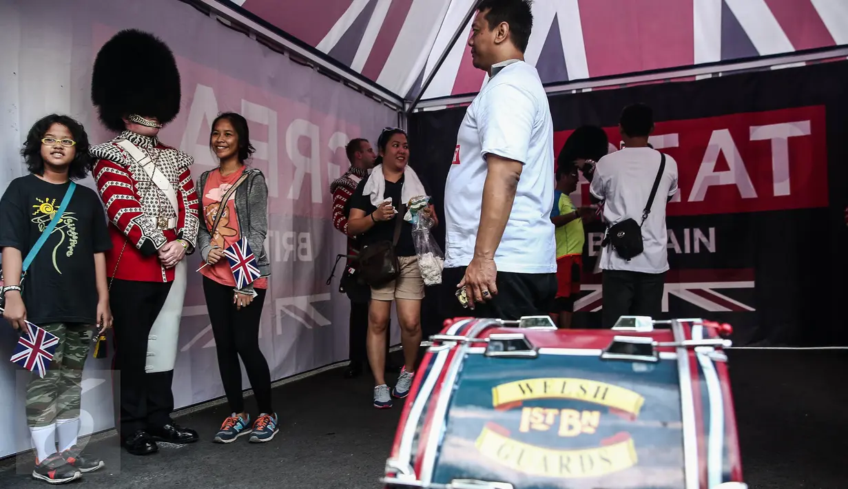 Dua orang remaja berpose disamping pasukan Scotts Guard alias penjaga Istana Inggris, usai beraksi di sela kegiatan Car Free Day (CFD) di kawasan Bundaran HI, Jakarta, Minggu (5/6). (Liputan6.com/Faizal Fanani)